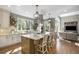 Open concept kitchen features a center island with seating, stone backsplash, modern lighting, and an eat-in kitchen at 3002 S Oak Way, Lakewood, CO 80227
