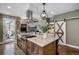 Gourmet kitchen featuring a central island, stainless steel hood, and a view of the outdoor space at 3002 S Oak Way, Lakewood, CO 80227