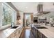 Bright open kitchen showcasing stainless hood, marble countertops and view of the patio and living room at 3002 S Oak Way, Lakewood, CO 80227