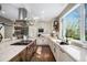 Spacious kitchen with stainless steel hood, custom cabinets, large island, and bright window view at 3002 S Oak Way, Lakewood, CO 80227
