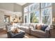 Bright open-concept living room with a view of the kitchen and large windows at 3002 S Oak Way, Lakewood, CO 80227