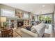 Comfortable living room featuring a stone fireplace, built-in shelves, and access to a sunroom at 3002 S Oak Way, Lakewood, CO 80227