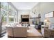 Sunlit living room featuring large windows, a stone fireplace, and comfortable sectional seating at 3002 S Oak Way, Lakewood, CO 80227