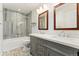 Bathroom with double vanity sinks and a shower-tub combo featuring tiled walls at 411 S Cody Ct, Lakewood, CO 80226