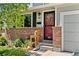 Close-up of the front entrance showcasing brick detail, a red front door, and house number at 411 S Cody Ct, Lakewood, CO 80226