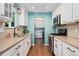 Updated kitchen with white cabinets, stainless steel appliances, and modern backsplash at 411 S Cody Ct, Lakewood, CO 80226