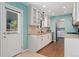 Well-lit kitchen featuring white cabinetry, modern appliances, and wood-look flooring at 411 S Cody Ct, Lakewood, CO 80226