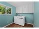 Laundry room with blue walls, wood-look flooring, and a window at 411 S Cody Ct, Lakewood, CO 80226