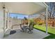 Covered patio with dining table, lush green lawn, garden bed and shed at 411 S Cody Ct, Lakewood, CO 80226