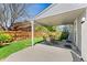 Covered patio with dining table, lush green lawn, and mature trees at 411 S Cody Ct, Lakewood, CO 80226
