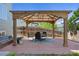 Backyard featuring a pergola, a brick patio with seating, and a well-maintained wooden fence at 18899 E Whitaker Cir, Aurora, CO 80015