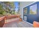Charming outdoor deck area with a dog door, wooden railings, and views of the backyard and trees at 18899 E Whitaker Cir, Aurora, CO 80015