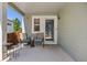 Covered patio area with chairs, a welcome mat, and an exterior door, perfect for outdoor relaxation at 18899 E Whitaker Cir, Aurora, CO 80015