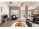 Bright living room featuring a ceiling fan, large windows, and seamless flow into the dining and kitchen areas at 8374 S Holland Way # 202, Littleton, CO 80128