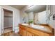 Bathroom featuring double sinks, spacious countertops, wood cabinets, and updated fixtures at 15800 E 121St Ave # L1, Brighton, CO 80603