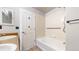 Bright bathroom with tub, shower, grab bar, and white tiled walls at 15800 E 121St Ave # L1, Brighton, CO 80603