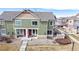 Two-story townhome with a well-manicured front yard and inviting red doors at 15800 E 121St Ave # L1, Brighton, CO 80603