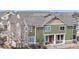 Exterior view of a multi-story townhome with green siding and a red door at 15800 E 121St Ave # L1, Brighton, CO 80603