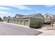 Row of green garages with stone veneer and well-manicured landscaping at 15800 E 121St Ave # L1, Brighton, CO 80603