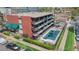 Aerial view of the brick building with balconies and a pool area, surrounded by greenery and urban residences at 200 N Pearl St # 106, Denver, CO 80203