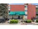 The condo building entrance features a green awning with well maintained landscape elements at 200 N Pearl St # 106, Denver, CO 80203