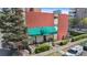Brick building exterior features a green awning with the address, manicured landscaping, and a secure entryway at 200 N Pearl St # 106, Denver, CO 80203