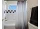 Modern bathroom features a shower/tub combination, gray tiled walls, and modern shower curtain at 9928 Bluestar Dr, Parker, CO 80138
