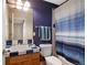 Cozy bathroom features blue tiled counter, wood vanity, and blue striped shower curtain at 9928 Bluestar Dr, Parker, CO 80138