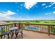 Scenic deck with wrought iron furniture overlooking a lush green landscape and sparkling pool below at 9928 Bluestar Dr, Parker, CO 80138