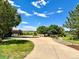 Long, curved driveway leading to a beautiful home surrounded by mature trees and well-maintained landscaping at 9928 Bluestar Dr, Parker, CO 80138