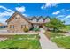 Charming home with inviting walkway, mature trees, well-manicured lawn, and stone and siding exterior at 9928 Bluestar Dr, Parker, CO 80138