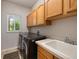Convenient laundry room with modern washer and dryer, sink and ample upper cabinet storage at 9928 Bluestar Dr, Parker, CO 80138