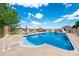 Luxury pool area with clear blue water, multiple lounge chairs, and a full outdoor kitchen at 9928 Bluestar Dr, Parker, CO 80138