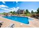 Backyard retreat with a sparkling pool, lounge chairs, outdoor kitchen, and meticulously kept landscaping at 9928 Bluestar Dr, Parker, CO 80138