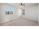 This bedroom features neutral carpet, a ceiling fan, and two large windows offering natural light at 6211 Bauer Dr, Frederick, CO 80504