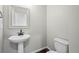 This powder room features a pedestal sink, modern faucet, and a framed mirror above at 6211 Bauer Dr, Frederick, CO 80504