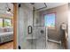Modern bathroom featuring a glass shower with a built-in seat, marble tiling, and a window with an outdoor view at 30717 Conifer Mountain Dr, Conifer, CO 80433