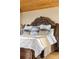 Close-up of a well-appointed bed with a decorative headboard, plush pillows, and a cozy throw blanket at 30717 Conifer Mountain Dr, Conifer, CO 80433