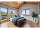 Bright bedroom features hardwood floors, vaulted wood ceiling, and a private balcony at 30717 Conifer Mountain Dr, Conifer, CO 80433