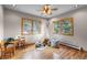 Bright bedroom featuring wood floors, a play tent, a wooden desk, and windows showcasing natural light and outdoor views at 30717 Conifer Mountain Dr, Conifer, CO 80433