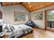 Cozy bedroom features hardwood floors, vaulted wood ceiling, and lots of natural light at 30717 Conifer Mountain Dr, Conifer, CO 80433