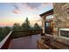 Outdoor deck features wood flooring and stone exterior, complemented by scenic sunset and mountain vistas at 30717 Conifer Mountain Dr, Conifer, CO 80433