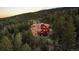 An inviting two-story home nestled in the trees with stone and red siding and wooden decks at 30717 Conifer Mountain Dr, Conifer, CO 80433