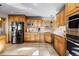 Spacious kitchen featuring knotty wood cabinetry, stainless steel appliances, and tile flooring at 30717 Conifer Mountain Dr, Conifer, CO 80433