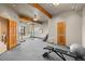 Spacious workout room with exposed wood beam architecture, multiple windows and carpet flooring at 30717 Conifer Mountain Dr, Conifer, CO 80433