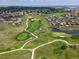 Stunning aerial view of a golf course community with lush greenery and water features at 1907 Windemere Ln, Erie, CO 80516