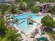 Stunning aerial view of a community pool with slides, lounge chairs, and a clubhouse at 1907 Windemere Ln, Erie, CO 80516