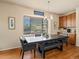 Bright dining room features a modern chandelier, wood floors, and a large window at 1907 Windemere Ln, Erie, CO 80516