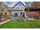 Spacious backyard featuring a lush green lawn, a deck, a patio area, and a unique treehouse at 553 S Sherman St, Denver, CO 80209