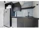 Basement bar area featuring sleek black cabinetry, stainless steel appliances, and stylish tile backsplash at 553 S Sherman St, Denver, CO 80209